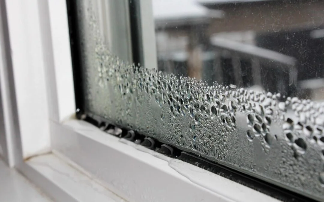 Heavy condensation and water droplets collecting on a white window frame